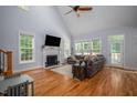 Bright living room with hardwood floors, fireplace, large windows, and vaulted ceiling with fan at 711 Kentcie Ln, Efland, NC 27243