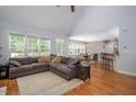 Open-concept living area with hardwood floors, connecting to the dining area and kitchen at 711 Kentcie Ln, Efland, NC 27243