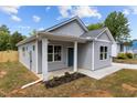 Stylish gray home featuring a welcoming porch, crisp white trim, and a well-maintained lawn at 815 Goshen St, Oxford, NC 27565