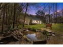 Serene backyard featuring a tranquil pond, landscaping, and a peaceful outdoor seating area at 85 Rolling Cloud Dr, Louisburg, NC 27549