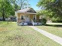 Traditional yellow home with a well-maintained lawn and mature trees, showcasing curb appeal at 1004 Fuller St, Smithfield, NC 27577