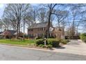 Classic two-story brick home with black shutters, complemented by a green lawn and mature landscaping at 1005 Brookview Dr, Elon, NC 27244