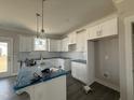 Well-lit kitchen showcasing white cabinets, stainless steel appliances, and a functional center island at 102 Ruskin Dr, Smithfield, NC 27577