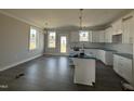 Bright, unfinished kitchen boasts white cabinetry, an island, and modern pendant lighting at 102 Ruskin Dr, Smithfield, NC 27577