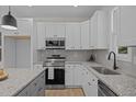 Modern kitchen features stainless steel appliances, granite counters, and white cabinetry at 111 Halifax Rd, Louisburg, NC 27549