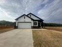 Newly built house with white siding, black trim, front-facing garage, and manicured lawn at 11778 Salers Loop, Middlesex, NC 27557