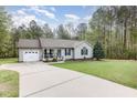 Well-kept single-story home featuring an attached garage, long driveway, and lush green front yard at 120 Renee Dr, Wilson's Mills, NC 27577
