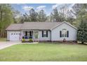 Inviting single-story home with a charming front porch, attached garage, and well-manicured lawn at 120 Renee Dr, Wilson's Mills, NC 27577