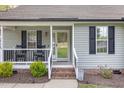 Welcoming front porch with rocking chairs, complemented by lush landscaping and a clear view of the entrance at 120 Renee Dr, Wilson's Mills, NC 27577