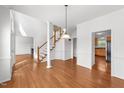 Dining room with hardwood floors, staircase, and view into the kitchen at 1308 Aspen Falls Ct, Willow Springs, NC 27592
