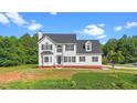 Lovely two-story home with a manicured lawn and beautiful, lush trees at 1308 Aspen Falls Ct, Willow Springs, NC 27592