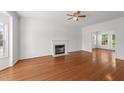 Bright living room with hardwood floors, fireplace, and natural light through large windows at 1308 Aspen Falls Ct, Willow Springs, NC 27592