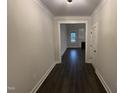 Hallway with dark wood floors leads to a living area with fireplace and large window at 141 Ruskin Dr, Smithfield, NC 27577