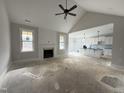 Bright living room featuring a fireplace, ceiling fan, and an open layout that leads to the kitchen at 141 Ruskin Dr, Smithfield, NC 27577