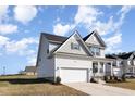 Beautiful two-story home features a front-facing garage and a well-maintained lawn, set against a blue sky at 15 Woodworkers Way, Clayton, NC 27520