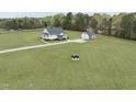 Expansive property featuring a lovely home, detached garage, and a buffalo statue on a sprawling green lawn at 184 Mort Harris Rd, Louisburg, NC 27549