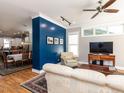 Open-concept living room with hardwood floors, a stylish blue accent wall, and modern furnishings at 1980 Great Ridge Pkwy, Chapel Hill, NC 27516