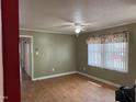 Open living area with a large window, ceiling fan, laminate floors, and neutral paint at 2102 Michael Ln, Smithfield, NC 27577