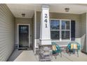 Inviting front porch with decorative columns, stylish seating, and a view of the landscaped yard at 241 N Nolan Park Dr, Selma, NC 27576