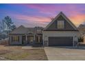 Charming two-story home featuring a two-car garage, landscaped yard and inviting front porch during sunset at 2440 Us 70 A, Selma, NC 27576