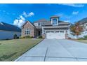 Charming two-story home with stone accents, lush lawn, two-car garage, and beautiful curb appeal at 2620 Club Level Dr, Apex, NC 27523