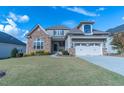 Charming two-story home with stone accents, lush lawn, two-car garage, and beautiful curb appeal at 2620 Club Level Dr, Apex, NC 27523