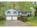 Inviting two-story home with blue shutters, a well-manicured lawn, and double garage doors at 2808 Newquay St, Durham, NC 27705