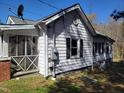 Side view of the home featuring white siding, classic shutters, and a screened-in porch at 307 Watson St, Creedmoor, NC 27522