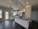 New kitchen featuring white cabinets, an island, modern pendant lights, and stainless steel appliances at 32 Tanseyleaf Dr, Smithfield, NC 27577