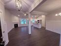 Open-concept living area featuring wood floors, a fireplace, and views into the modern kitchen at 32 Tanseyleaf Dr, Smithfield, NC 27577