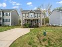 Two-story home with a long concrete driveway, well-manicured lawn, and lush green landscaping at 329 Chamberlain Dr, Clayton, NC 27527