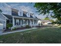 Attractive home featuring a cozy front porch, well-manicured lawn, and colorful flowerbeds at 35 Fairway Ct, Dunn, NC 28334