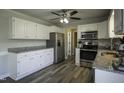 Modern kitchen with stainless steel appliances, white cabinets, and granite countertops at 35 Fairway Ct, Dunn, NC 28334