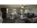Inviting living room featuring laminate flooring, a ceiling fan, and plenty of natural light at 35 Fairway Ct, Dunn, NC 28334