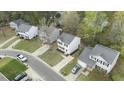 An aerial view shows a well-placed two-story home with green spaces, driveways, and surrounding neighborhood at 3717 Phillips W Way, Durham, NC 27713