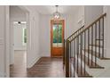 Bright entryway with hardwood floors, wooden staircase, and a clear view of the front door at 390 Pilot Ridge Rd, Zebulon, NC 27597