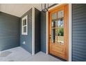 Close up of wood and glass paneled front door with overhead lantern style lighting at 390 Pilot Ridge Rd, Zebulon, NC 27597