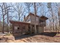 Rustic home featuring a screened porch and natural wood siding, nestled among mature trees at 4401 E L G Rd, Efland, NC 27243