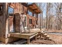Inviting wooden deck with rocking chair and seating, perfect for relaxing in a tranquil setting at 4401 E L G Rd, Efland, NC 27243
