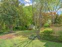 Spacious backyard featuring a wooden deck, mature trees, and lush landscaping, ideal for outdoor activities at 4508 Fox Rd, Raleigh, NC 27616