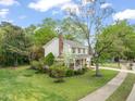 View of the two-story home showcasing the manicured lawn and mature trees surrounding the property at 4508 Fox Rd, Raleigh, NC 27616