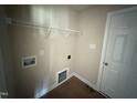 A practical laundry area equipped with a wire shelf and connections for a washer and dryer at 47 Silver Ct, Smithfield, NC 27577