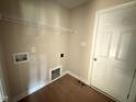 A compact laundry room with wire shelving and hookups for a washer and dryer at 47 Silver Ct, Smithfield, NC 27577