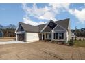Charming home with light siding, covered entrance, and manicured lawn at 48 Tanseyleaf Dr, Smithfield, NC 27577