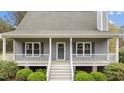 A welcoming front porch with white railings and stairs, perfect for relaxing outdoors at 4810 Mitchell Mill Rd, Wake Forest, NC 27587