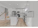 Modern kitchen with stainless steel appliances, white cabinets, subway tile backsplash, and a kitchen island at 5430 Crabtree Park Ct, Raleigh, NC 27612