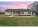 Charming single-story home with a covered front porch, green siding, black shutters, and well-maintained lawn at 5570 Normans Rd, Rougemont, NC 27572