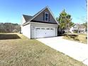 A well-maintained home featuring a spacious two-car garage with a long driveway on a sunny day at 6320 Slopeside Ct, Raleigh, NC 27610