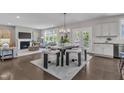 Bright open-concept dining room showcasing a fireplace, modern light fixture, and access to the kitchen at 706 Fireball Ct, Knightdale, NC 27545