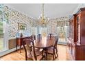 Elegant dining room with floral wallpaper, wood floors, and a vintage chandelier at 7201 Jonathan Dr, Wendell, NC 27591